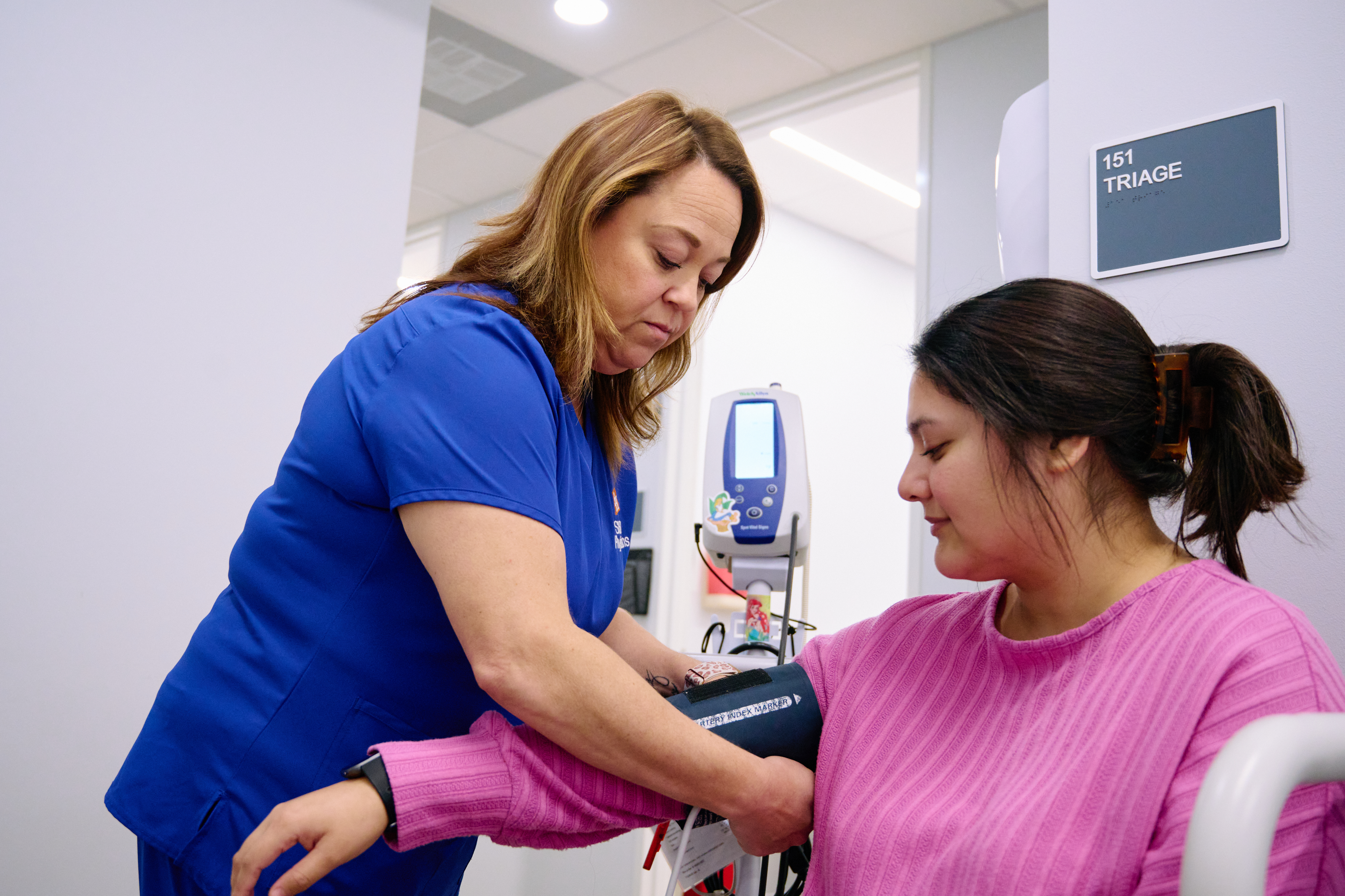 Nurse with patient taking blood pressure