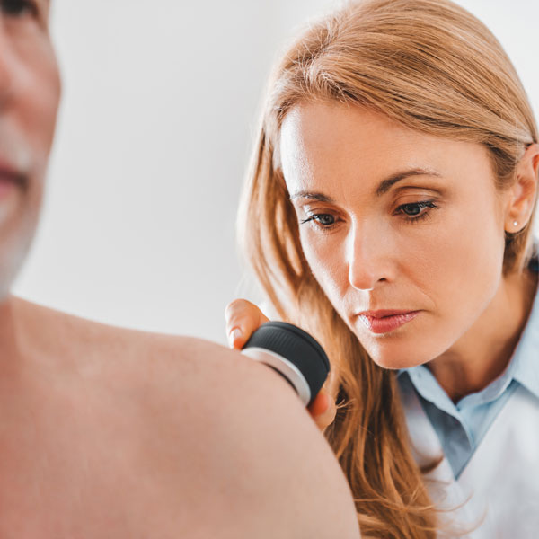 doctor looking at patient's skin